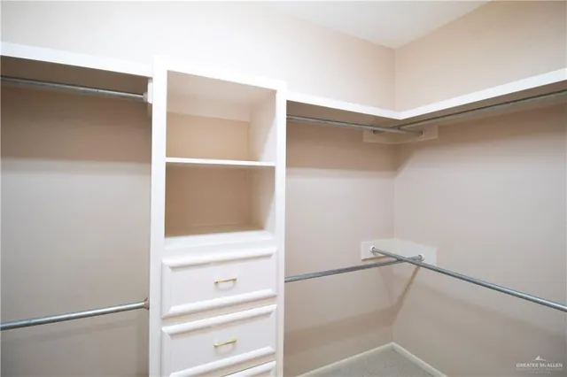a view of walk in closet with empty racks