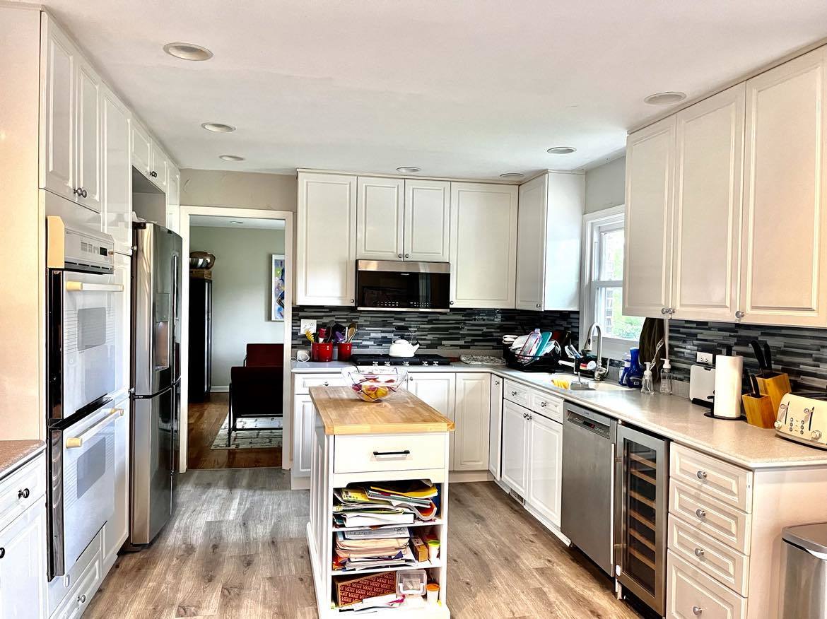 958 Suffield Terrace Northbrook, IL 60062 - Photo 8 of 39 a kitchen with a refrigerator a stove a sink and white cabinets with wooden floor