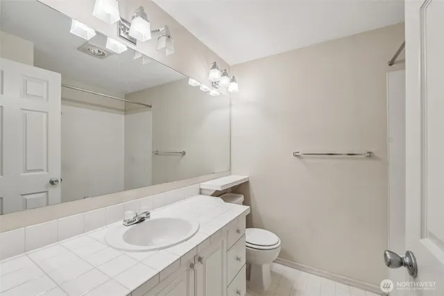 a bathroom with a sink vanity granite and toilet