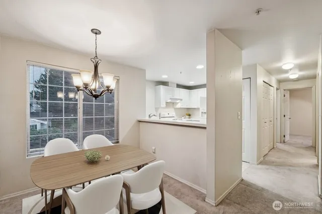 a view of a dining room and a kitchen with a chandelier