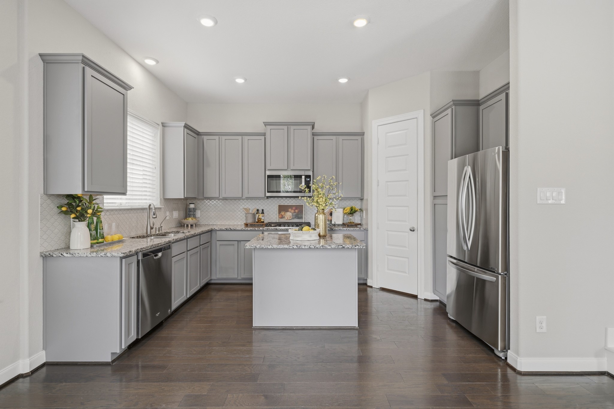 4103 Tranquil Square Road Houston, TX 77043 - Photo 11 of 39 Designed for connection, the kitchen features an oversized island with breakfast bar seating, ideal for morning coffee, casual meals or hosting guests.