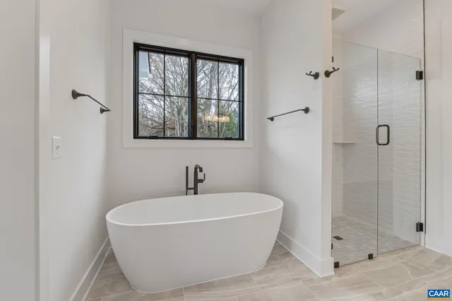a white bath tub sitting next to a shower