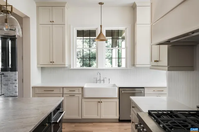 a kitchen with white cabinets and stove