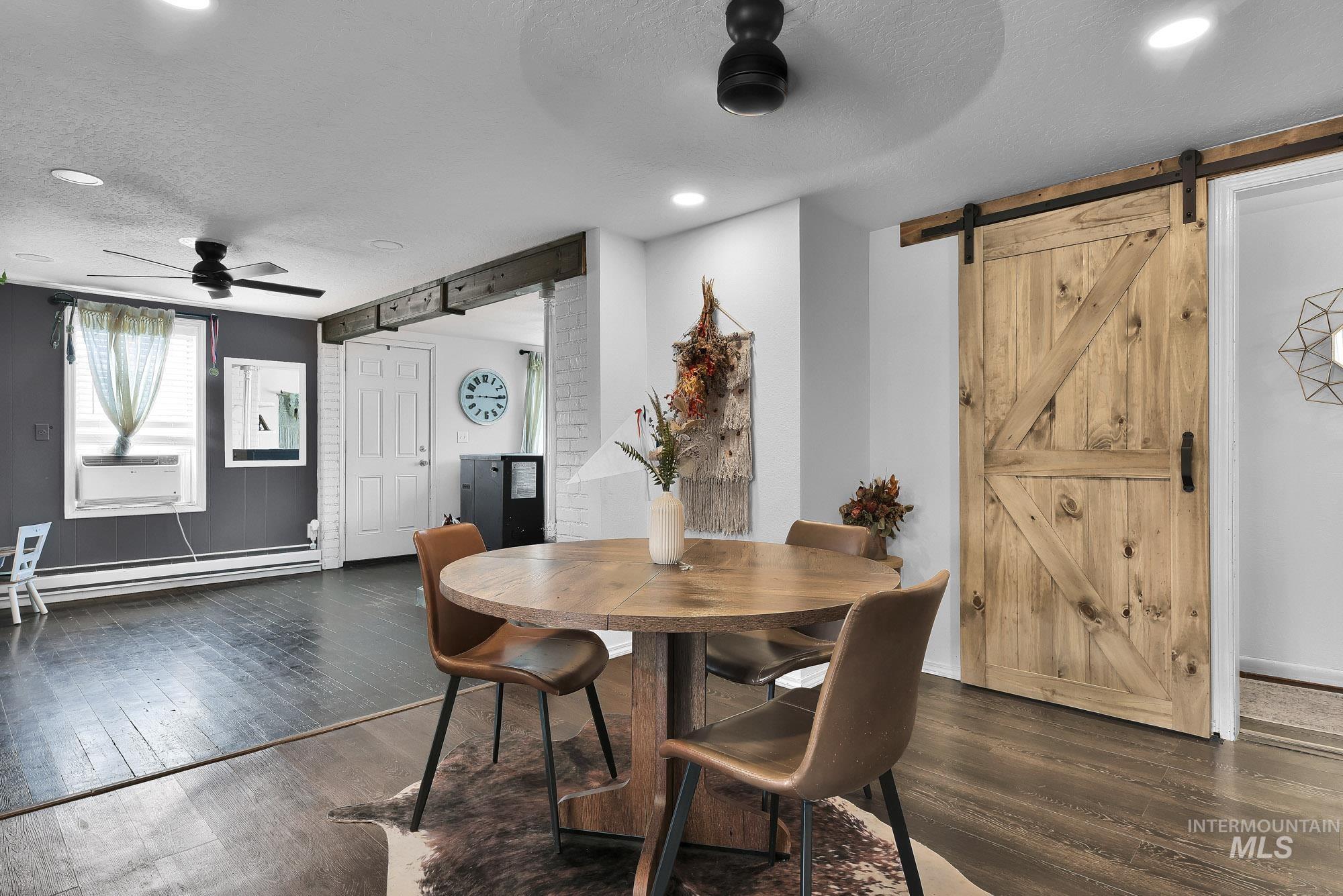 24900 Market Road Parma, ID 83660 - Photo 38 of 50 Reclaimed wood-style barn door with black hardware, wood-finish flooring, and recessed ceiling lighting