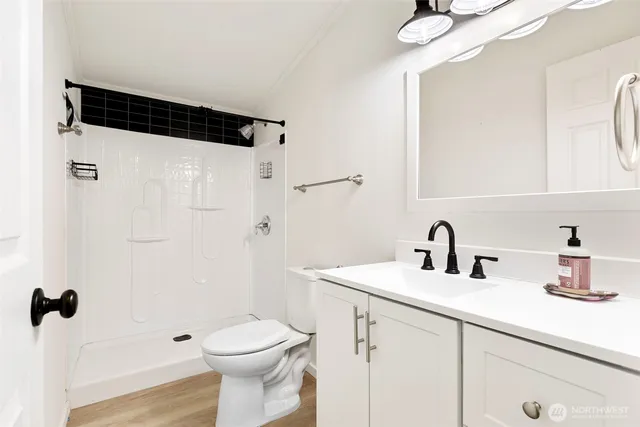 a bathroom with a sink a toilet and shower