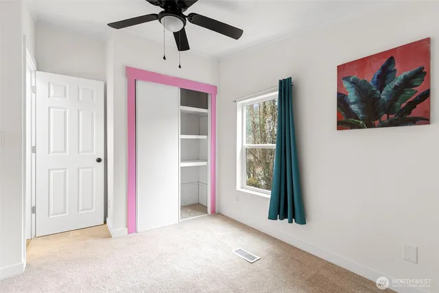 an empty room with windows and ceiling fan