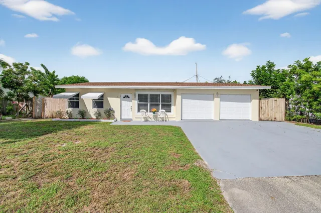 a view of a house with a yard and potted plants