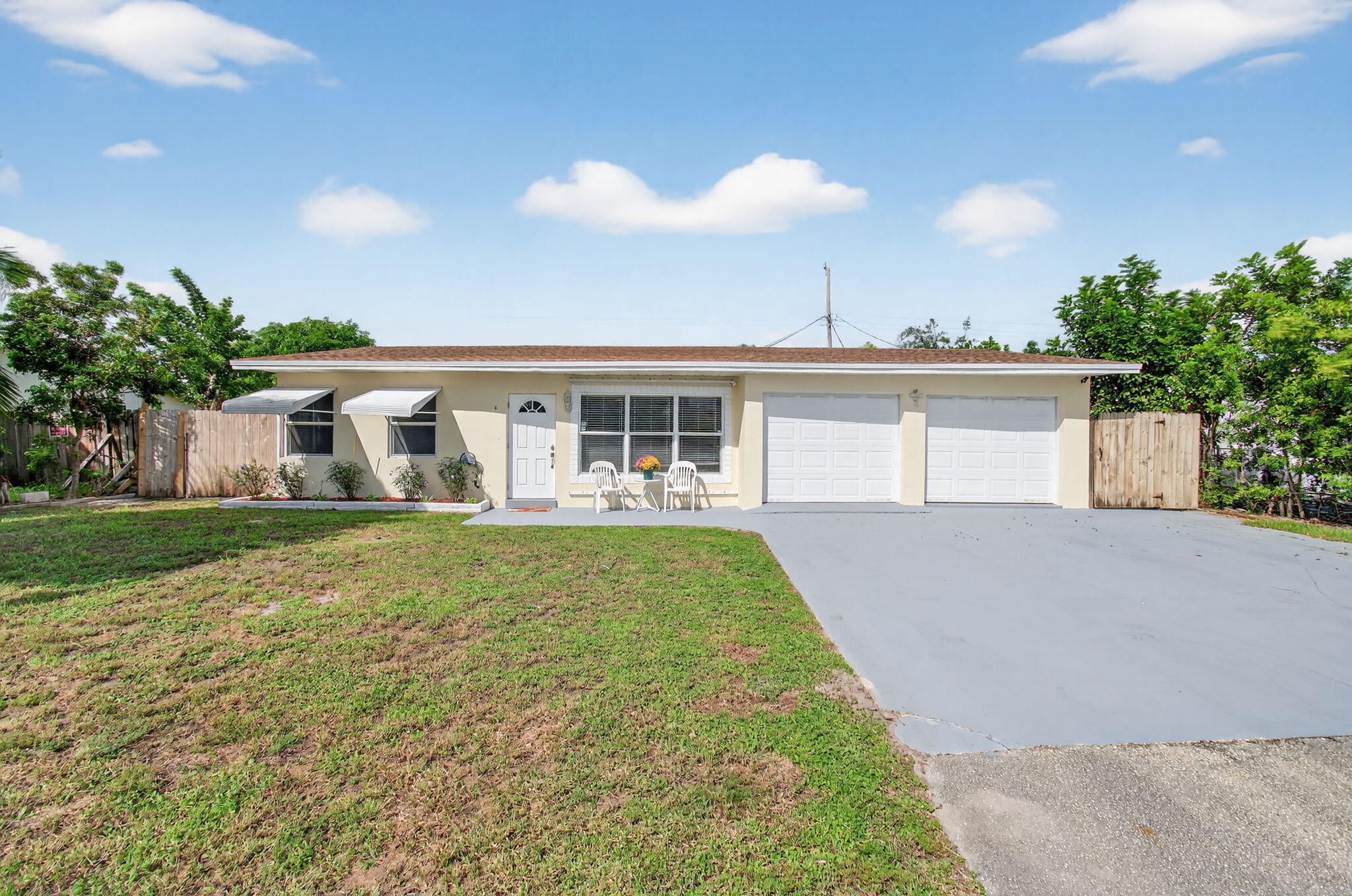 a view of a house with a yard and potted plants