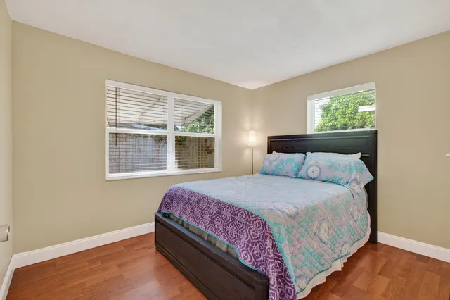 a bathroom with a granite countertop sink vanity mirror and toilet