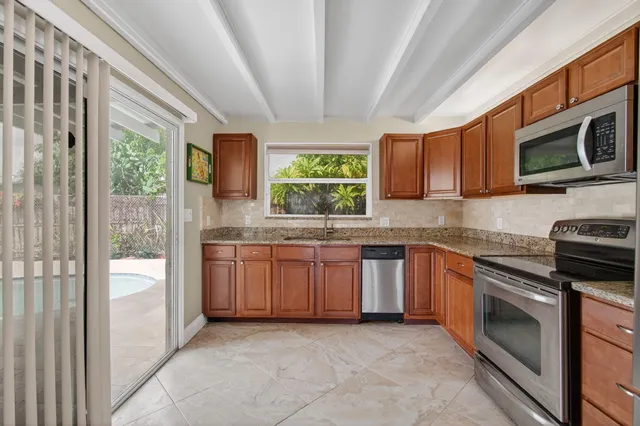 a kitchen with stainless steel appliances granite countertop a stove microwave and sink