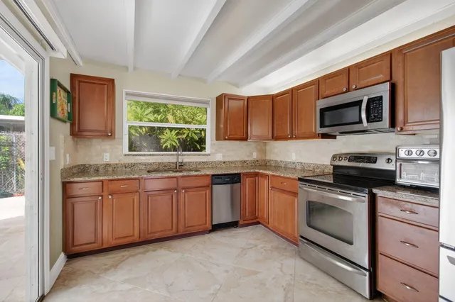 a kitchen with stainless steel appliances granite countertop a refrigerator stove and sink