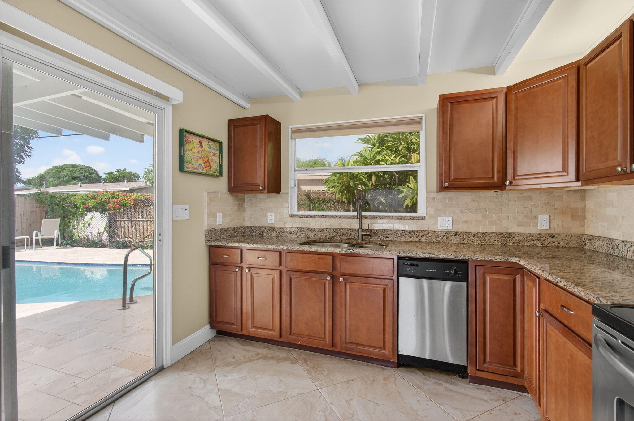 2841 Northeast 8th Terrace Pompano Beach, FL 33064 - Photo 25 of 65 a kitchen with granite countertop a sink and a stove