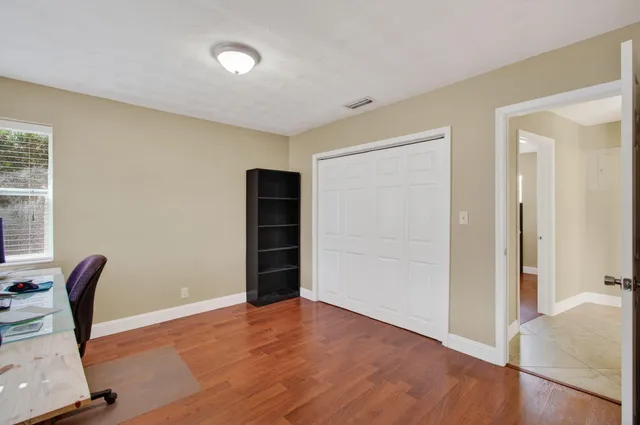 a backyard of a house with table and chairs potted plants and a wooden fence