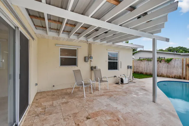 a view of a backyard with potted plants and wooden fence