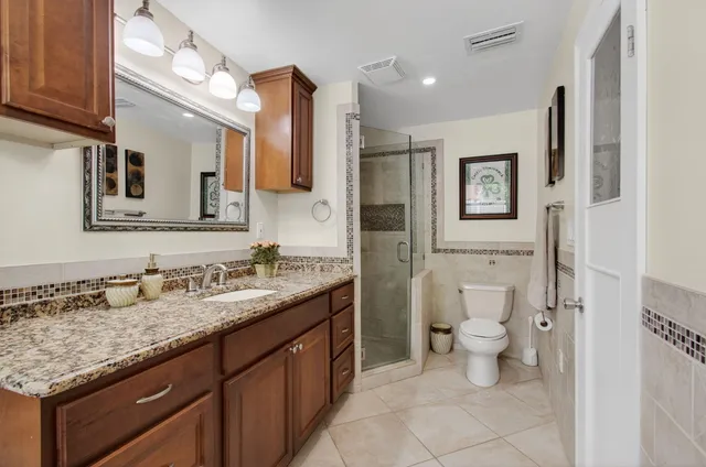 a bathroom with a granite countertop sink toilet and shower