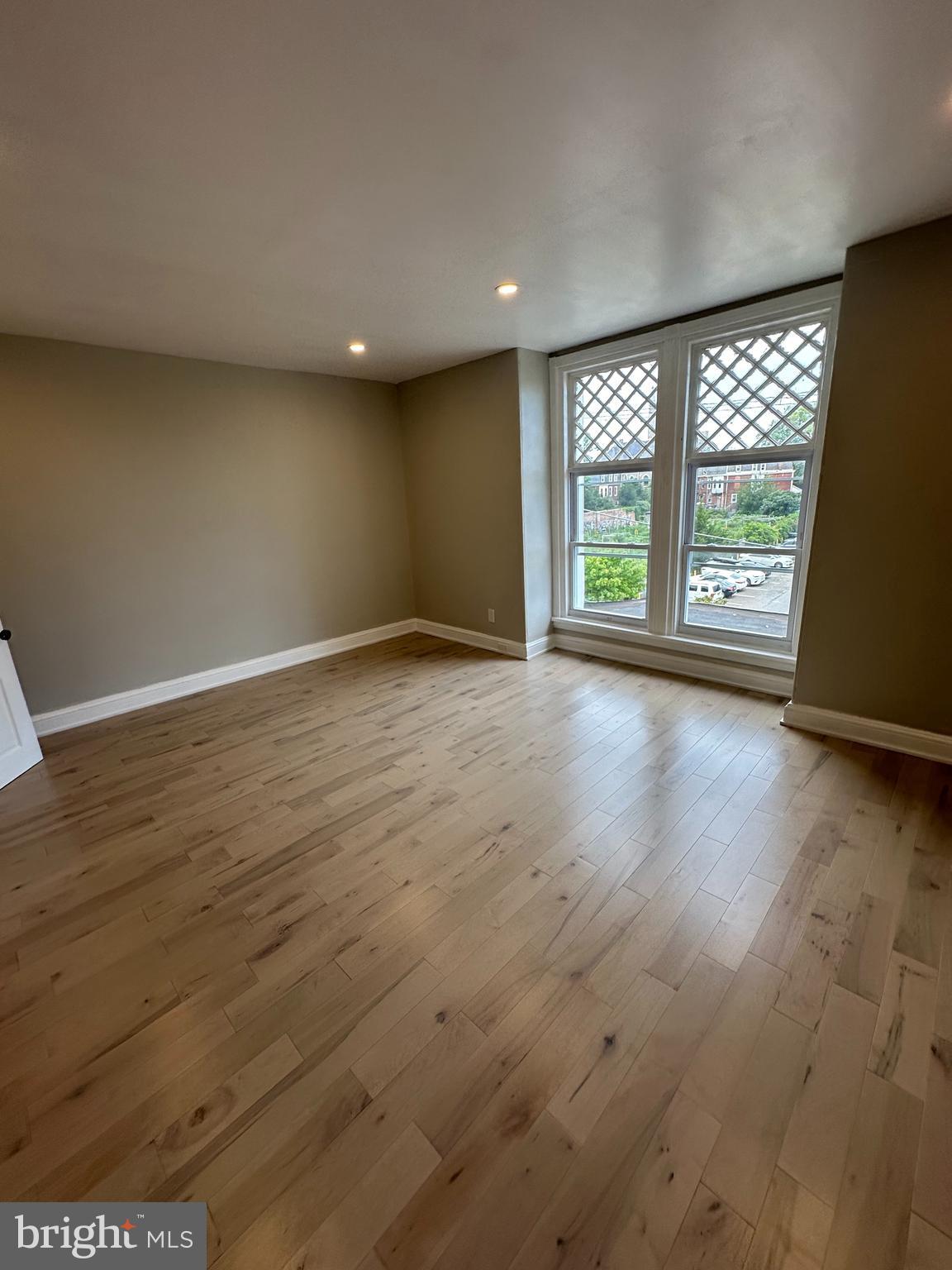 4710 Warrington Avenue, Unit 3 Philadelphia, PA 19143 - Photo 22 of 32 a view of an empty room with wooden floor and a window