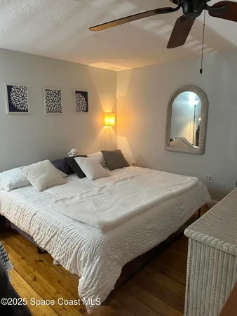 a bedroom with a bed and a painting on the wall