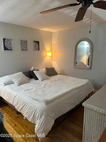 a bedroom with a bed and a painting on the wall