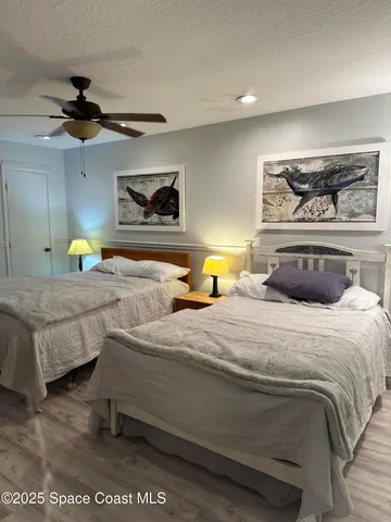 a bedroom with bed and ceiling fan