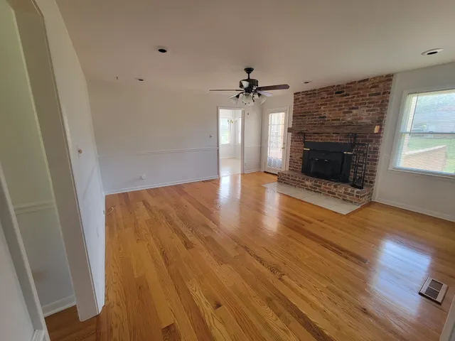 a view of a livingroom with wooden floor and a fireplace