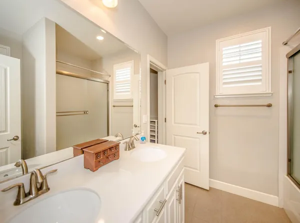 a bathroom with a sink tub vanity and a mirror