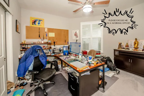 a view of a workspace with furniture and a window