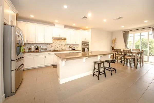 a kitchen with a table chairs stove and cabinets