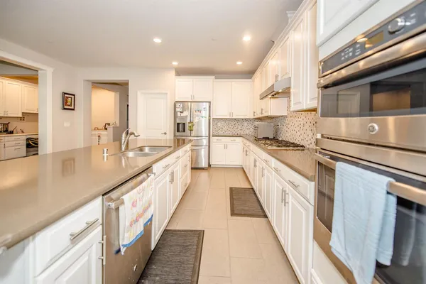 a large kitchen with stainless steel appliances and a counter space