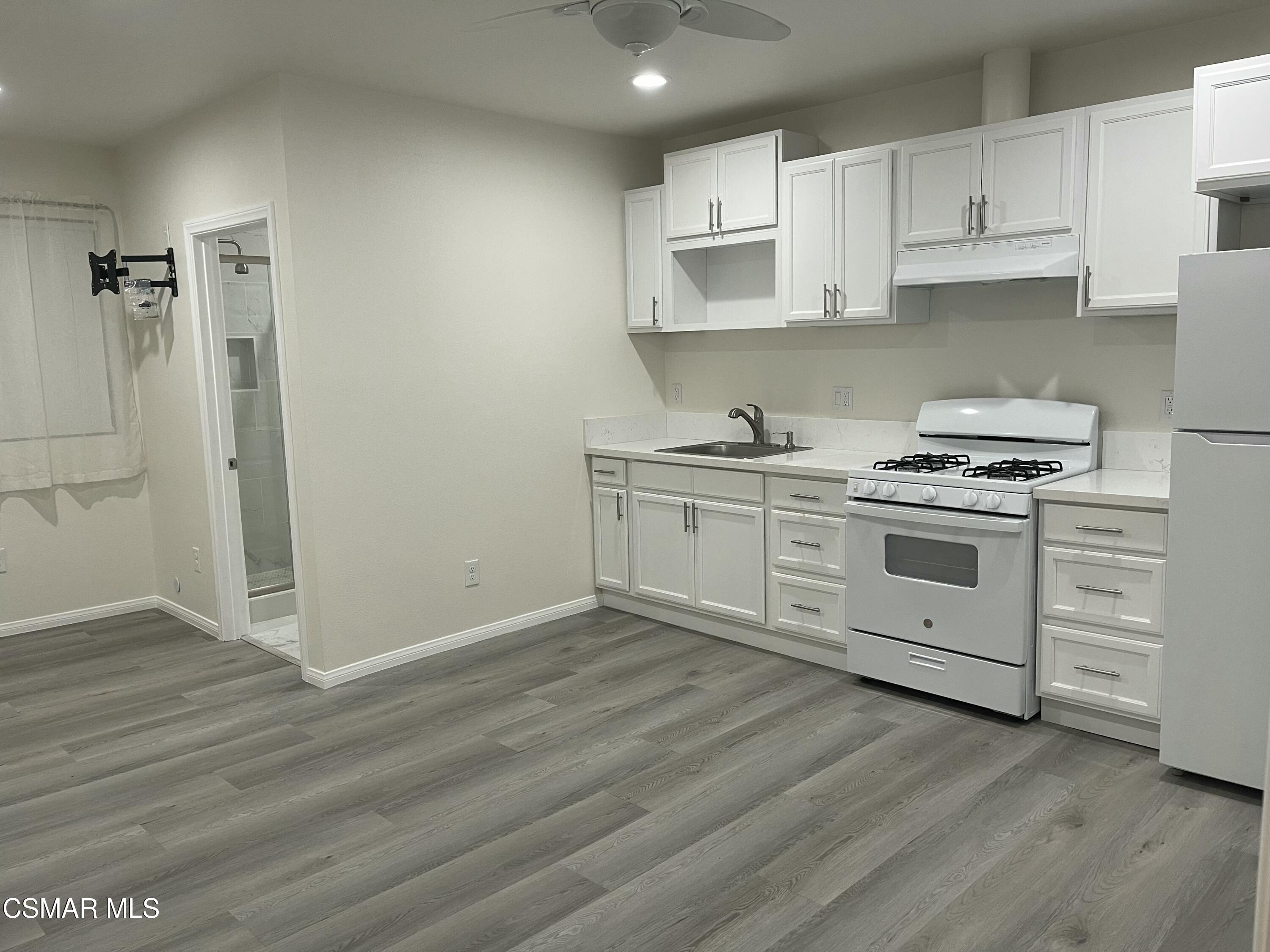 a kitchen with a stove cabinets and wooden floor