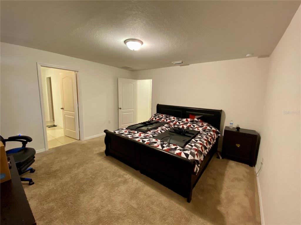 8659 Silverbell Loop Brooksville, FL 34613 - Photo 20 of 36 a bed sitting in a bedroom next to a window and a lamp