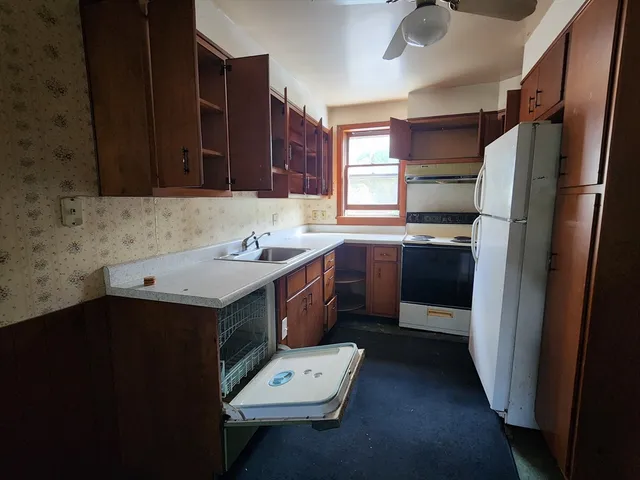 a kitchen with a sink a stove a refrigerator and cabinetry
