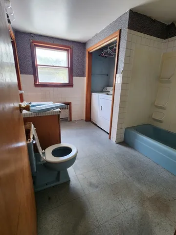 a bathroom with a toilet a sink and mirror