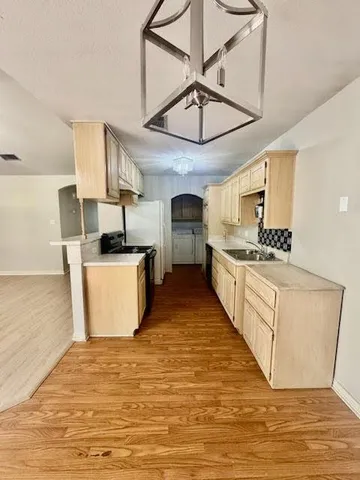 a large white kitchen with cabinets a sink and a stove
