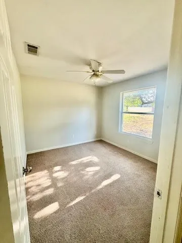 a view of a livingroom with a ceiling fan and window