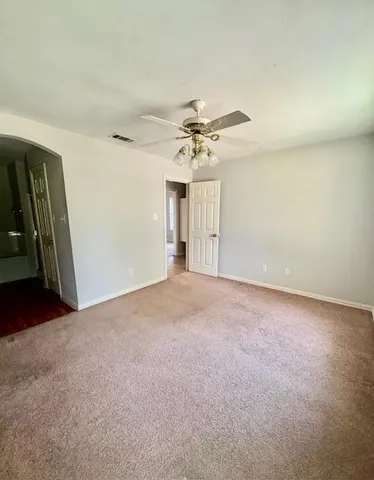 a view of a big room with chandelier fan and windows
