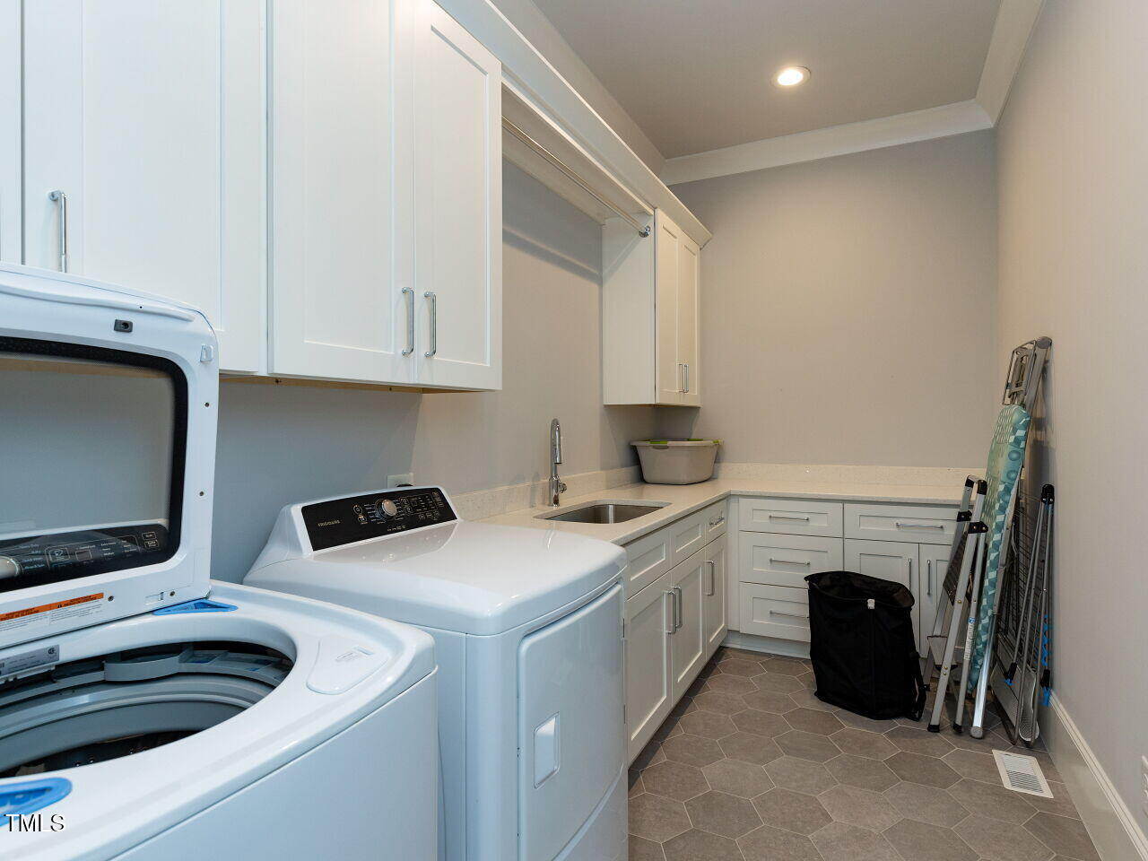 3416 Edgemont Drive Raleigh, NC 27612 - Photo 40 of 49 Laundry room with upper and lower cabinets and sink.