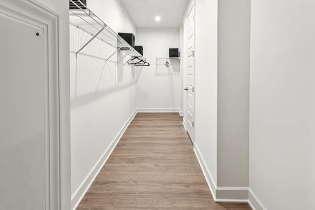 a view of a hallway with wooden floor and staircase
