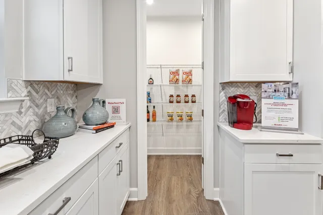 a kitchen with stainless steel appliances white cabinets and a wooden floor