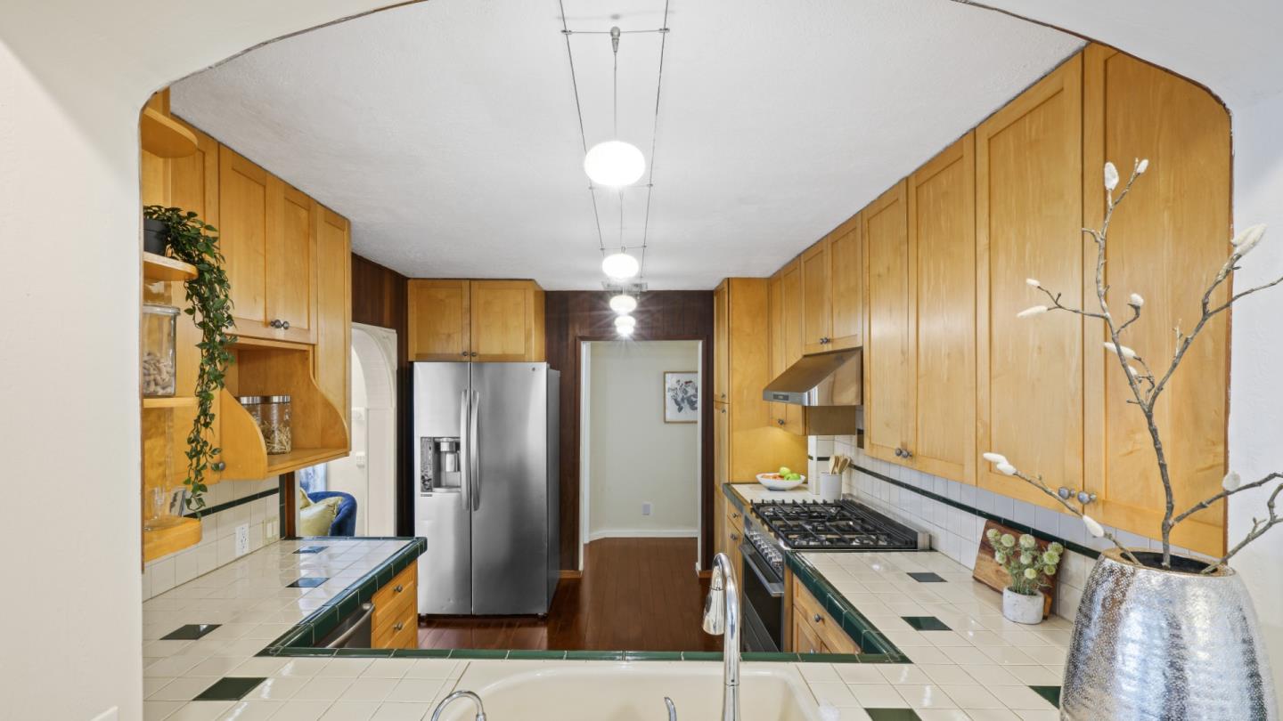 338 Kings Road Brisbane, CA 94005 - Photo 36 of 53 a kitchen with stainless steel appliances kitchen island granite countertop a table chairs in it and wooden floors