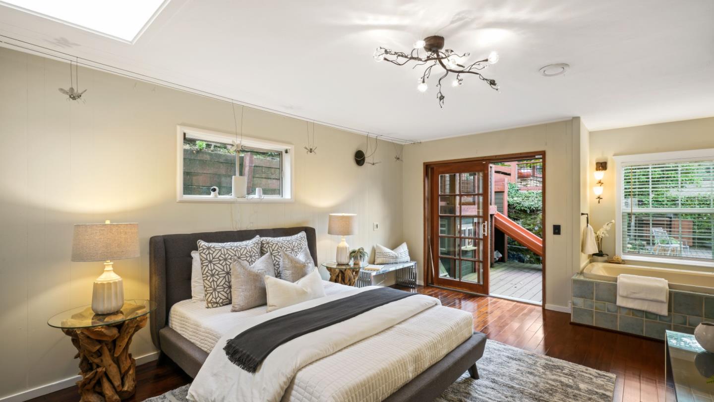 338 Kings Road Brisbane, CA 94005 - Photo 41 of 53 a bedroom with a large bed a chandelier and a window