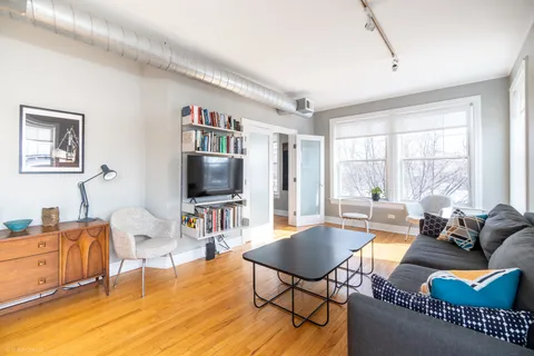 a living room with furniture a flat screen tv and a large window
