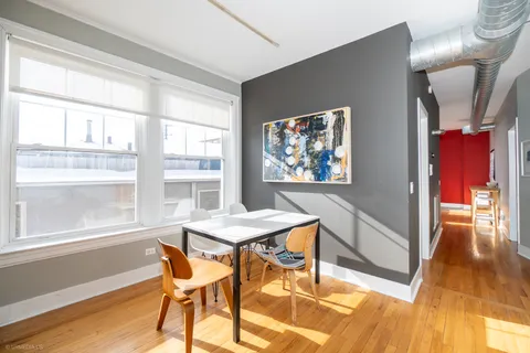 a view of a dining room with furniture a chandelier and wooden floor
