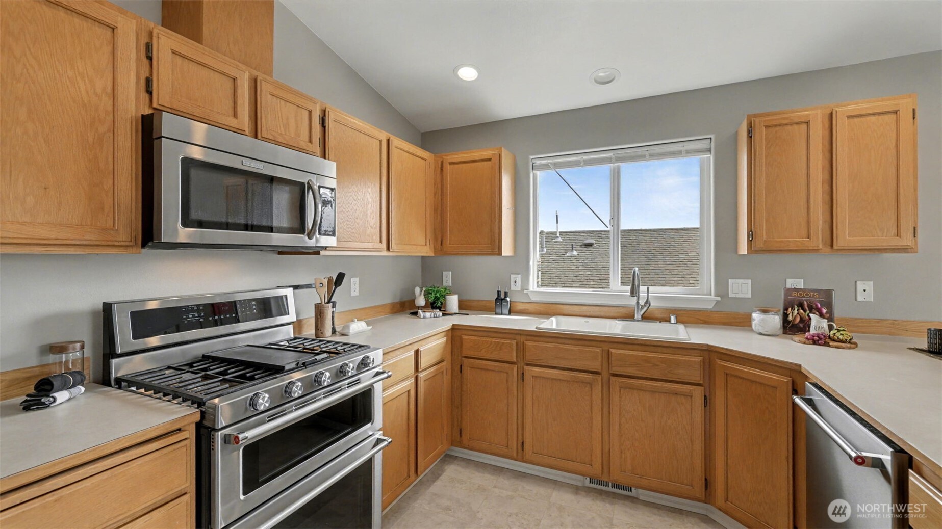 132 76th Place Southwest Everett, WA 98203 - Photo 17 of 36 a kitchen with stainless steel appliances a sink a stove a microwave cabinets and a window