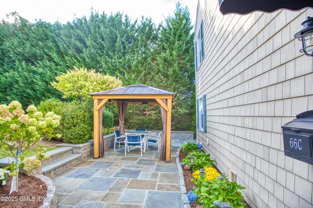 a view of a patio with table and chairs potted plants with wooden fence