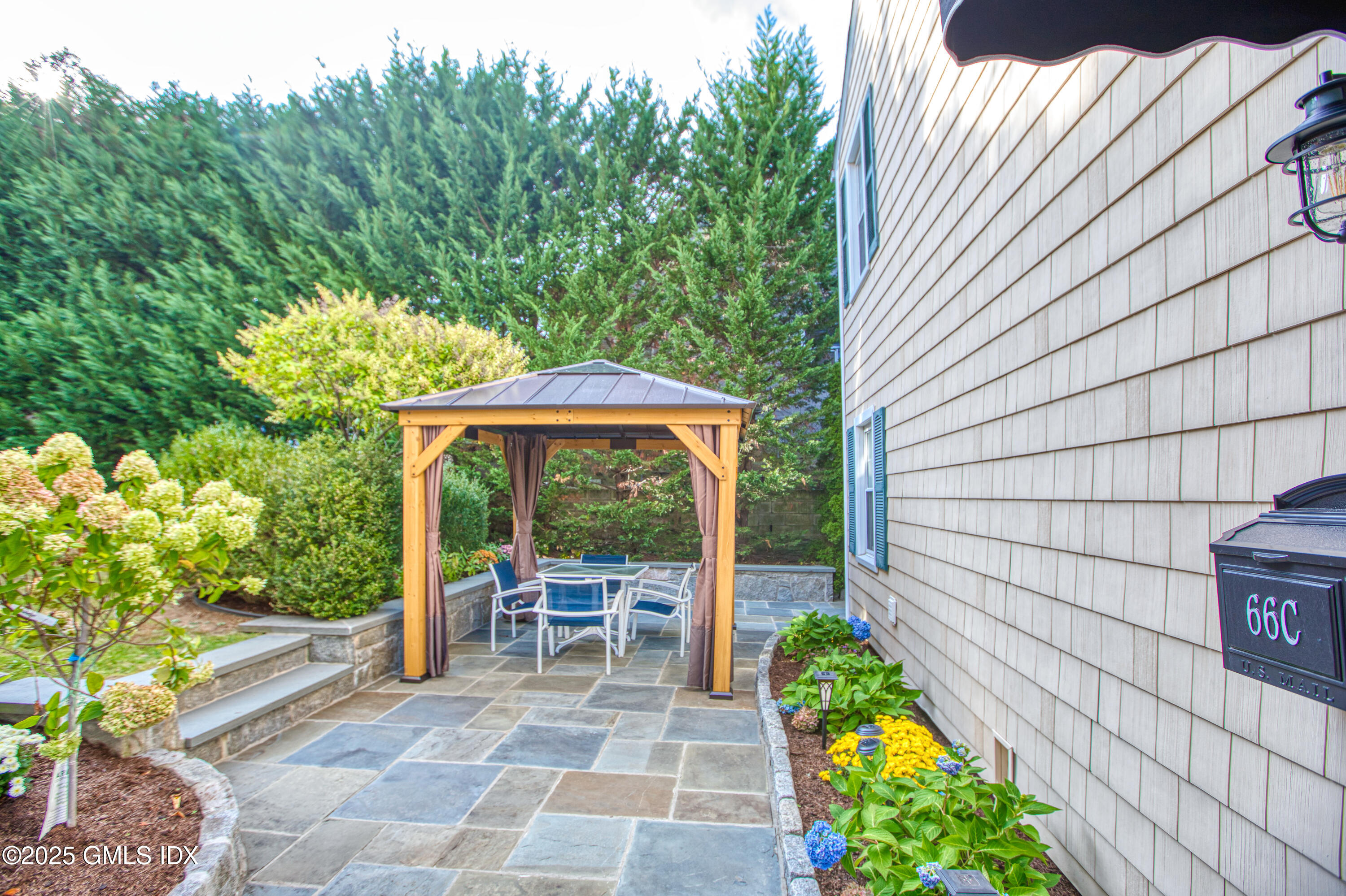 66 Ute Place, Unit C Greenwich, CT 06830 - Photo 16 of 18 a view of a patio with table and chairs potted plants with wooden fence