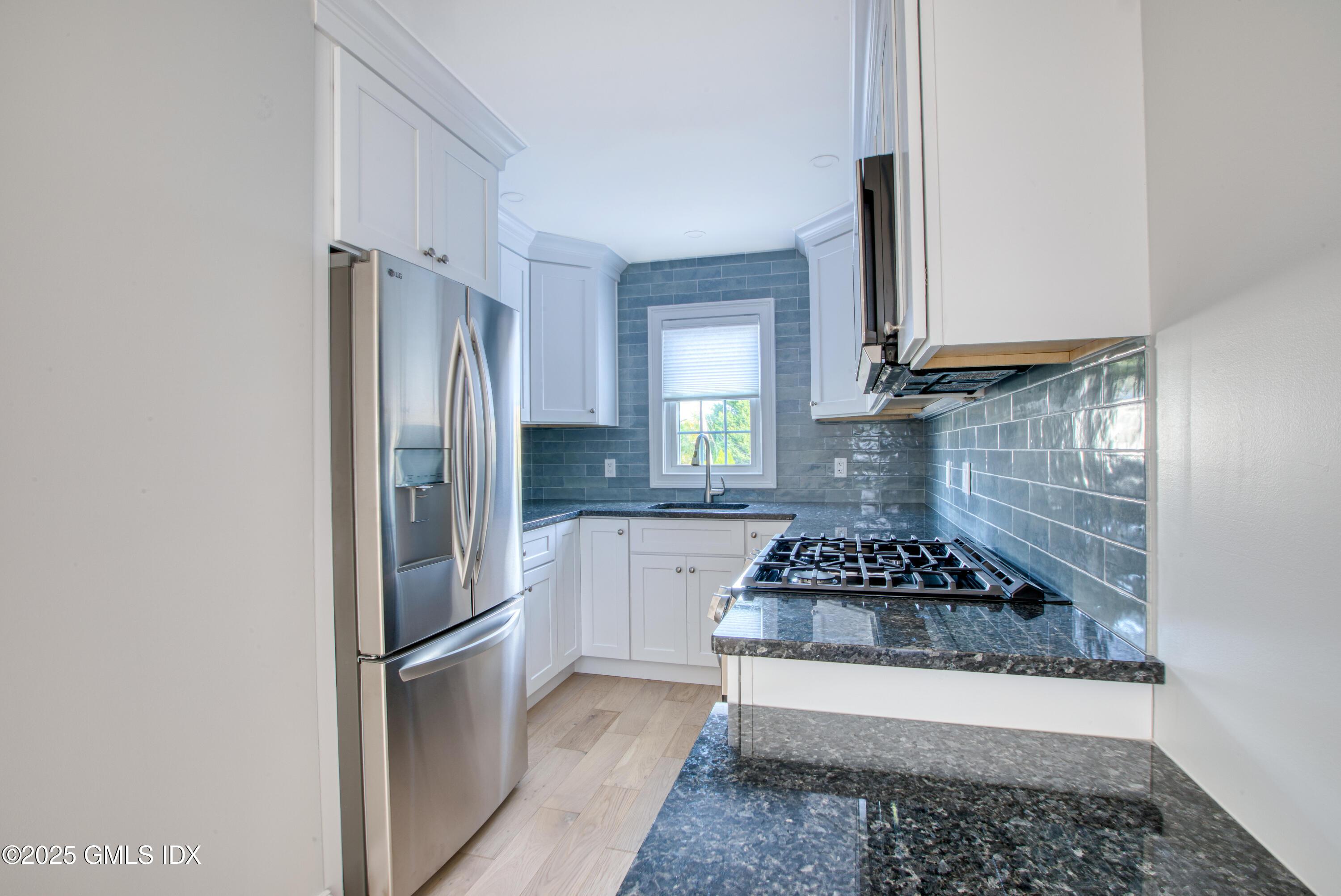 66 Ute Place, Unit C Greenwich, CT 06830 - Photo 5 of 18 a kitchen with a refrigerator stove and cabinets
