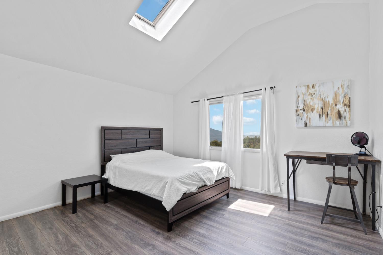 40707 Jean Road East Oakhurst, CA 93644 - Photo 21 of 44 a bedroom with a bed table chair and a window