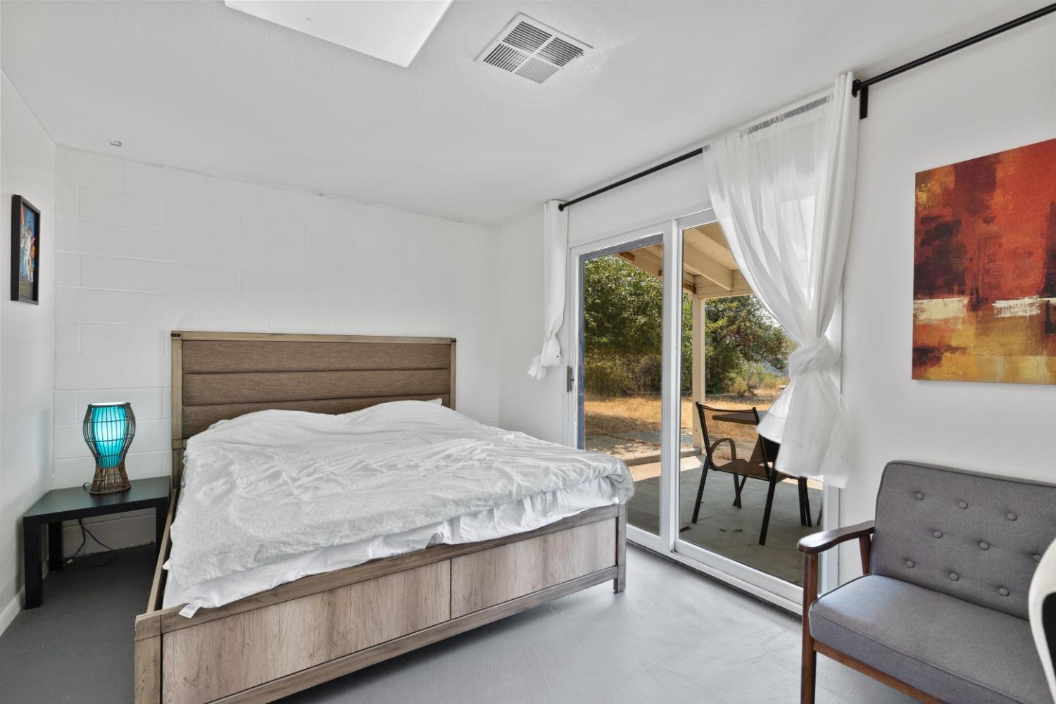 40707 Jean Road East Oakhurst, CA 93644 - Photo 25 of 44 a bedroom with a bed couch and a large window