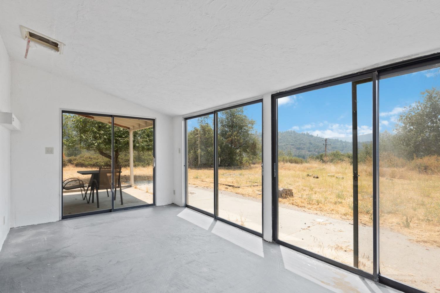 40707 Jean Road East Oakhurst, CA 93644 - Photo 28 of 44 a view of an empty room with wooden floor and a window