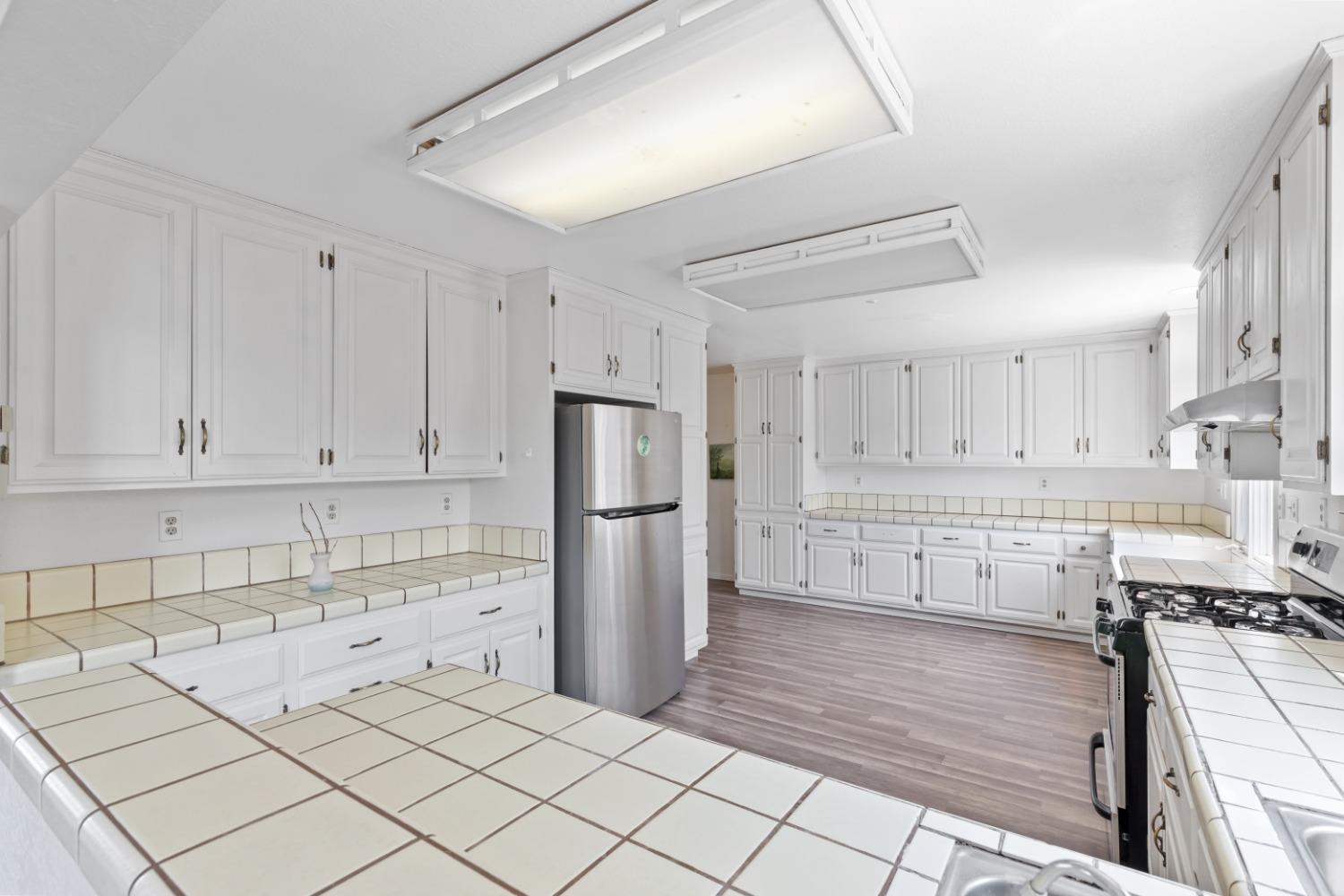 40707 Jean Road East Oakhurst, CA 93644 - Photo 9 of 44 a kitchen with white cabinets and refrigerator